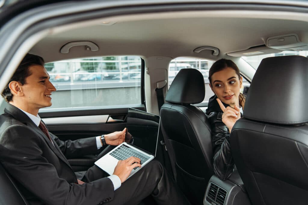 driver talking to businessman with laptop in taxi 2022 12 16 19 53 13 utc 1024x683